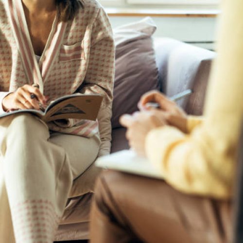 Two women in armchairs are sitting and talking. Woman psychologist practicing with  patient women. Coach session between girlfriends. Therapist's gestures. Female talking in the office